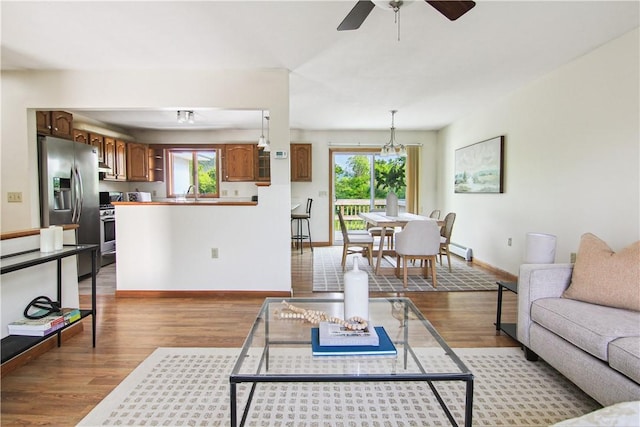 9 Jacob Dr, Erwin, NY 14870 - living room with wood finished floors, plenty of natural light, a ceiling fan, and a baseboard heating unit