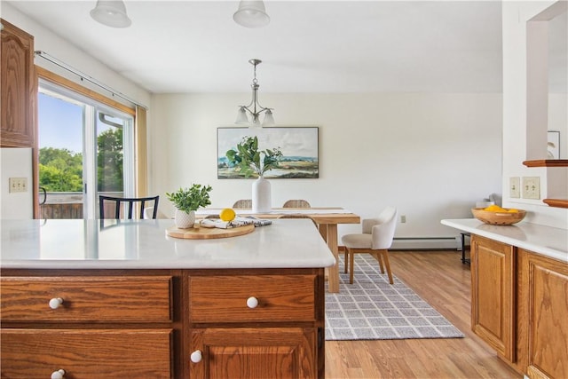 9 Jacob Dr, Erwin, NY 14870 - kitchen featuring light countertops, baseboard heating, light wood-style floors, brown cabinets, and hanging light fixtures