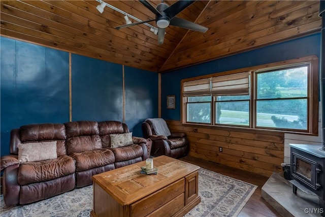 10256 State Route 26, Denmark, NY 13367 - living room with vaulted ceiling, a ceiling fan, a wood stove, wooden ceiling, and wood finished floors