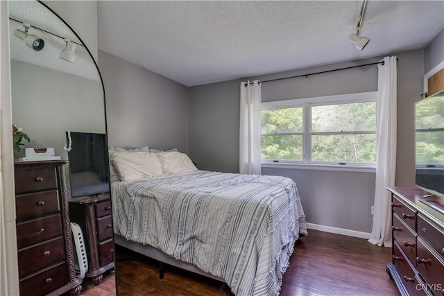10256 State Route 26, Denmark, NY 13367 - bedroom featuring rail lighting, a textured ceiling, and dark wood-type flooring