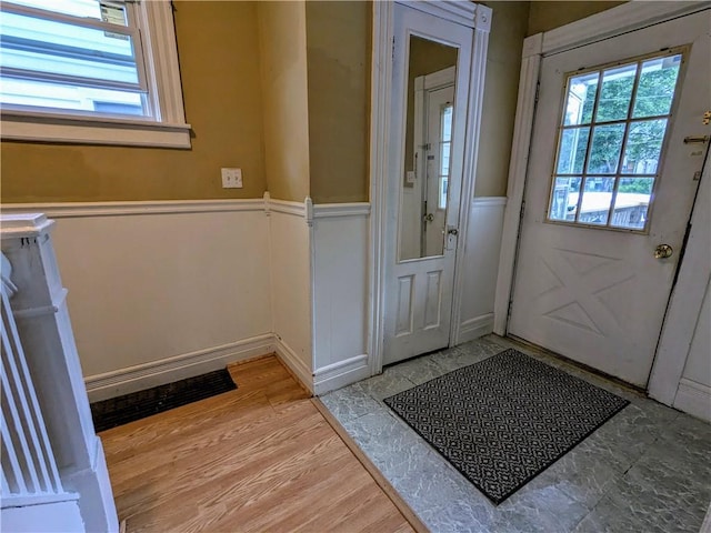 354 Euclid Ave, Elmira City, NY 14905 - doorway to outside featuring plenty of natural light, a wainscoted wall, a decorative wall, and light wood-type flooring