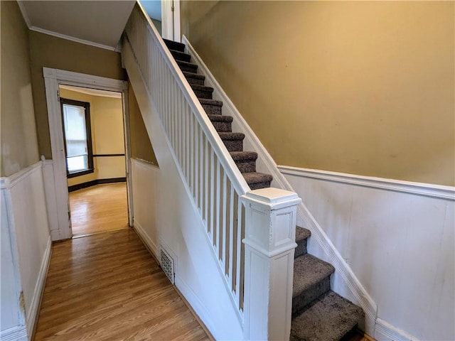 354 Euclid Ave, Elmira City, NY 14905 - stairway with wood finished floors, a wainscoted wall, ornamental molding, and a decorative wall