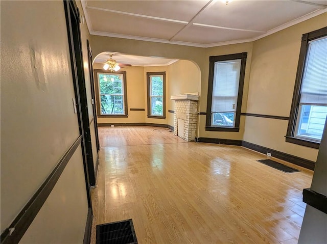 354 Euclid Ave, Elmira City, NY 14905 - unfurnished living room with arched walkways, light wood-style flooring, ceiling fan, a brick fireplace, and crown molding