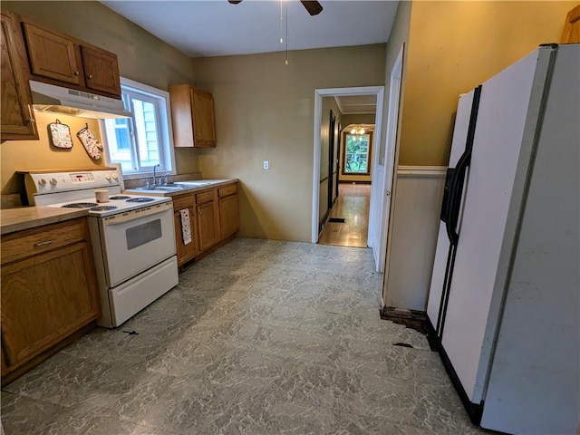 354 Euclid Ave, Elmira City, NY 14905 - kitchen with white appliances, under cabinet range hood, brown cabinets, and ceiling fan