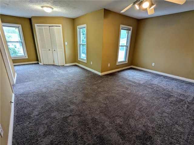 354 Euclid Ave, Elmira City, NY 14905 - unfurnished bedroom with carpet, multiple windows, a textured ceiling, a closet, and ceiling fan