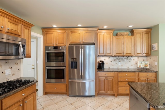 2371 Bullis Rd, Elma, NY 14059 - kitchen with stainless steel appliances, decorative backsplash, dark stone counters, light tile patterned floors, and recessed lighting