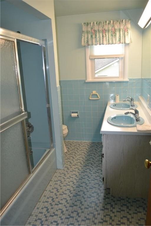 229 Everclay Dr, Greece, NY 14616 - bathroom with wainscoting, tile walls, double vanity, and shower / bath combination with glass door