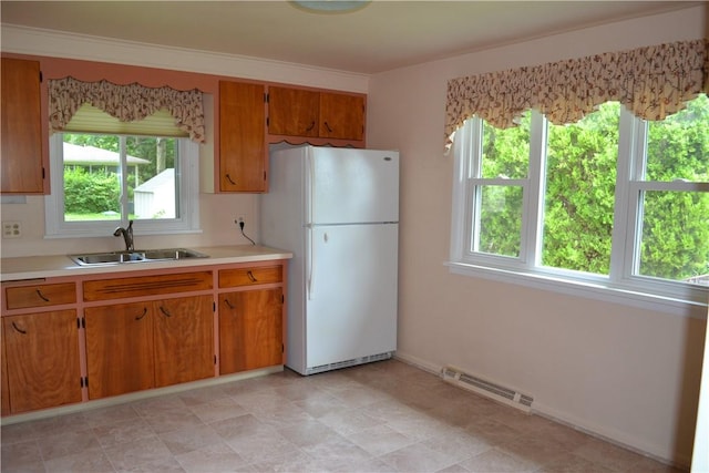 229 Everclay Dr, Greece, NY 14616 - kitchen with freestanding refrigerator, light countertops, and brown cabinetry