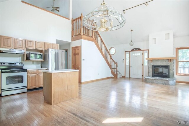 29591 Coon Bridge Rd, Theresa, NY 13691 - kitchen with stainless steel appliances, under cabinet range hood, high vaulted ceiling, open floor plan, and light brown cabinetry