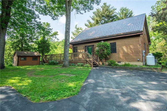 29591 Coon Bridge Rd, Theresa, NY 13691 - view of front of house with a front yard, crawl space, a wooden deck, a metal roof, and a storage unit
