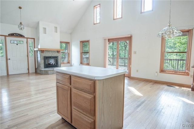 29591 Coon Bridge Rd, Theresa, NY 13691 - kitchen with high vaulted ceiling, healthy amount of natural light, a fireplace, light wood-style flooring, and pendant lighting