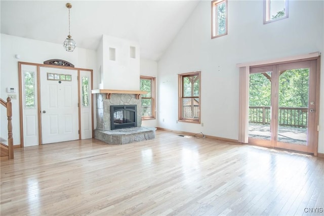 29591 Coon Bridge Rd, Theresa, NY 13691 - unfurnished living room featuring high vaulted ceiling, wood finished floors, and a stone fireplace