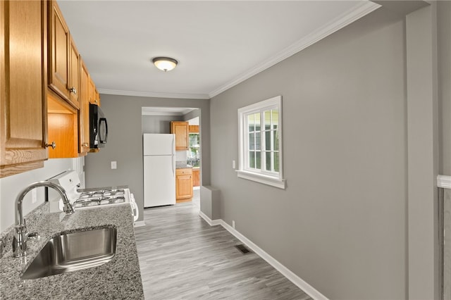 213 Auburn Ave, Gates, NY 14606 - kitchen with freestanding refrigerator, black microwave, stove, crown molding, and light wood-type flooring