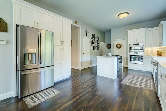 1544 Paddy Ln, Macedon, NY 14502 - kitchen featuring appliances with stainless steel finishes, dark wood-style flooring, white cabinets, and decorative backsplash