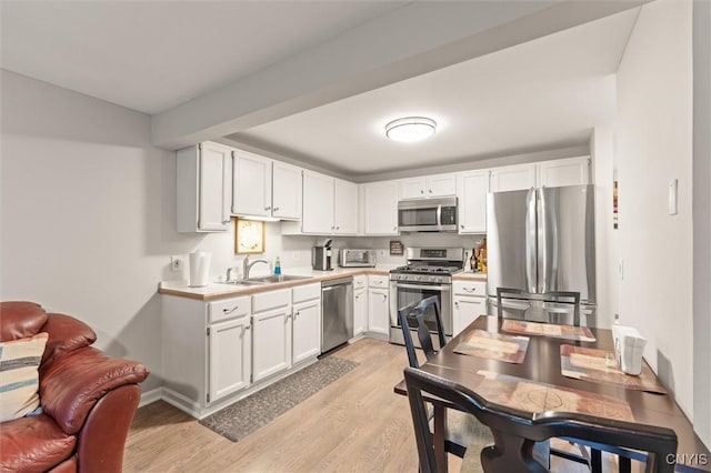101 Post Lamp Cir, Cicero, NY 13212 - kitchen with stainless steel appliances, light countertops, light wood-style flooring, and white cabinets