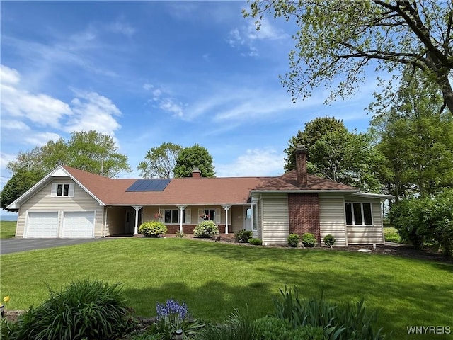 749 Lake Rd, Porter, NY 14174 - ranch-style home with solar panels, a porch, asphalt driveway, a front lawn, and a garage