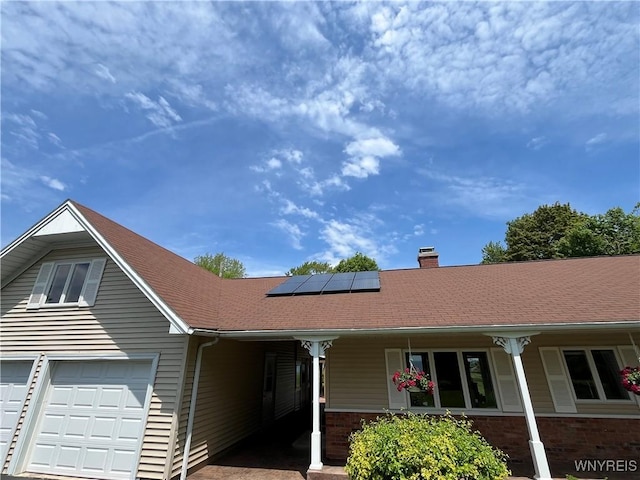 749 Lake Rd, Porter, NY 14174 - ranch-style home with a chimney, a porch, roof mounted solar panels, and brick siding