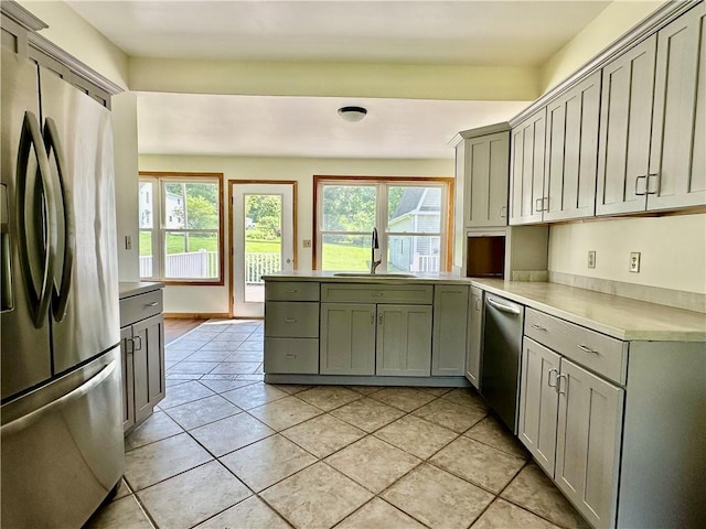 540 Derrick Rd, Foster-Town, PA 16701 - kitchen with appliances with stainless steel finishes, light tile patterned floors, light countertops, a peninsula, and gray cabinetry
