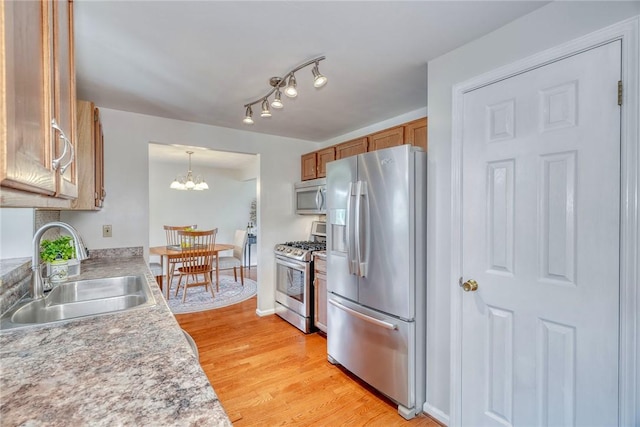 731 Brookeville Dr, Webster, NY 14580 - kitchen featuring appliances with stainless steel finishes, brown cabinets, a chandelier, and light countertops