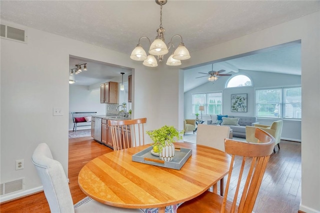 731 Brookeville Dr, Webster, NY 14580 - dining area with vaulted ceiling, a ceiling fan, light wood-style flooring, and a chandelier