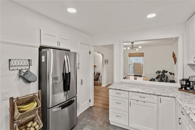 144 Montclair Dr, Irondequoit, NY 14617 - kitchen with stainless steel refrigerator with ice dispenser, arched walkways, white cabinets, light stone countertops, and recessed lighting