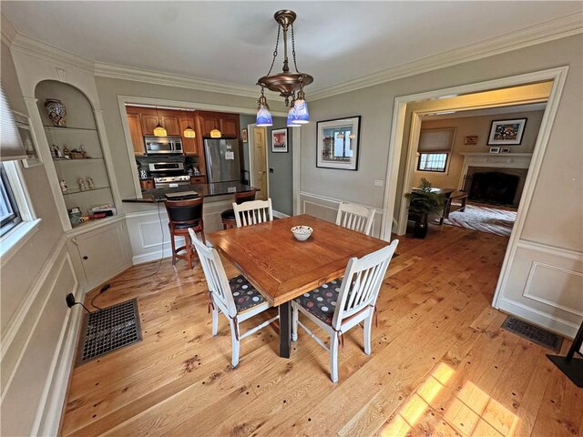 283 Bonnie Brae Ave, Brighton, NY 14618 - dining space featuring light wood-type flooring, crown molding, and a fireplace