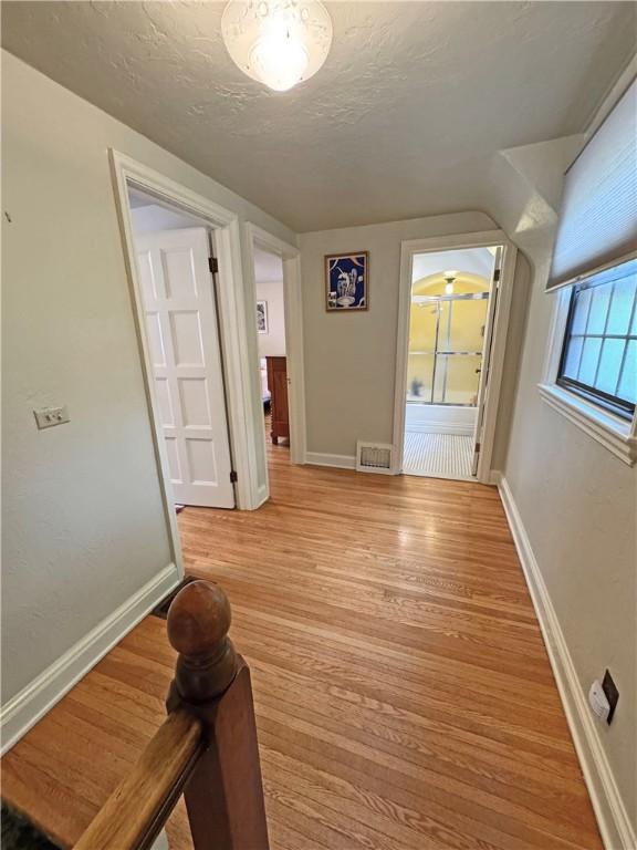 283 Bonnie Brae Ave, Brighton, NY 14618 - corridor featuring light wood-style floors and a textured ceiling