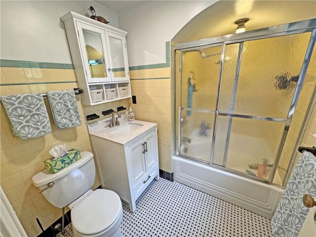 283 Bonnie Brae Ave, Brighton, NY 14618 - full bath with tile walls, vanity, bath / shower combo with glass door, and wainscoting