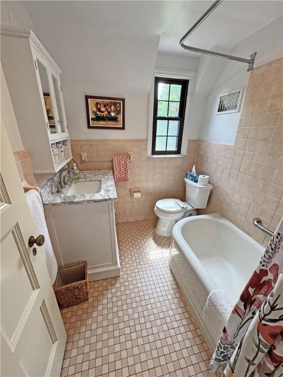 283 Bonnie Brae Ave, Brighton, NY 14618 - bathroom featuring tile walls, vanity, tile patterned floors, and a wainscoted wall