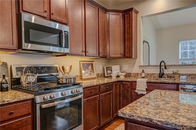 8497 Melo Cir, Clay, NY 13041 - kitchen with stainless steel appliances, light stone counters, and light wood-style floors