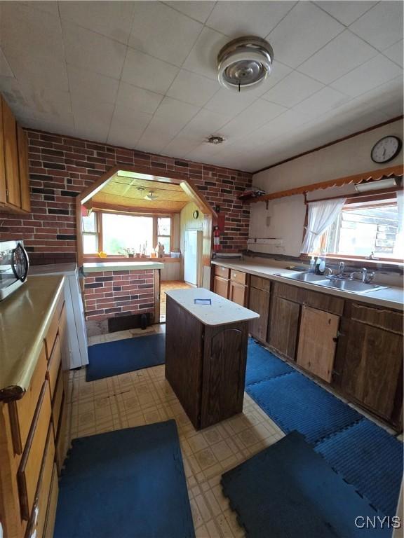 124 Seneca Ave, Sullivan, NY 13032 - kitchen with light floors, plenty of natural light, stainless steel microwave, light countertops, and brick wall