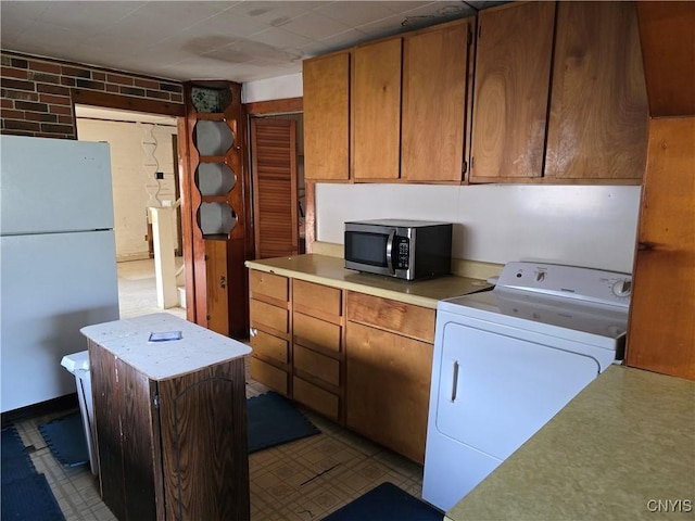 124 Seneca Ave, Sullivan, NY 13032 - kitchen with washer / clothes dryer, stainless steel microwave, freestanding refrigerator, light countertops, and brown cabinetry