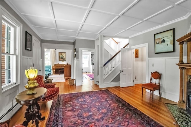 2565 Bowen Rd, Elma, NY 14059 - living area featuring wood finished floors, stairway, coffered ceiling, a baseboard heating unit, and ornamental molding