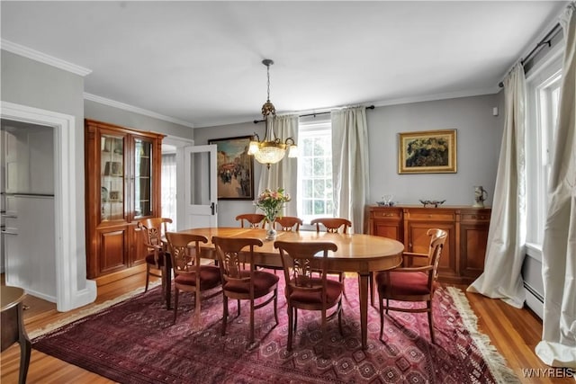 2565 Bowen Rd, Elma, NY 14059 - dining area with light wood finished floors, a baseboard heating unit, and crown molding
