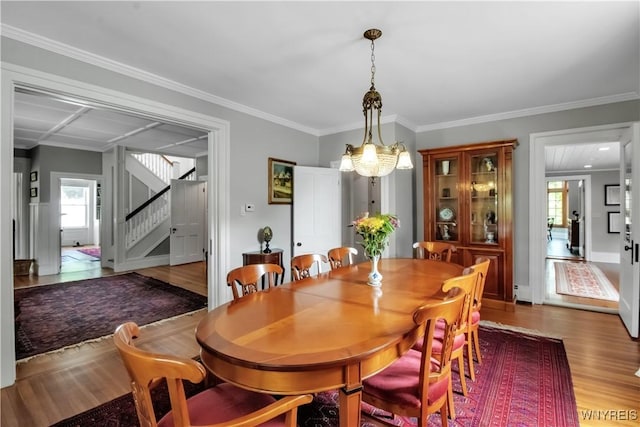 2565 Bowen Rd, Elma, NY 14059 - dining room featuring wood finished floors, stairway, healthy amount of natural light, ornamental molding, and a chandelier