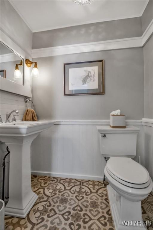 2565 Bowen Rd, Elma, NY 14059 - half bathroom featuring wainscoting, crown molding, and a decorative wall