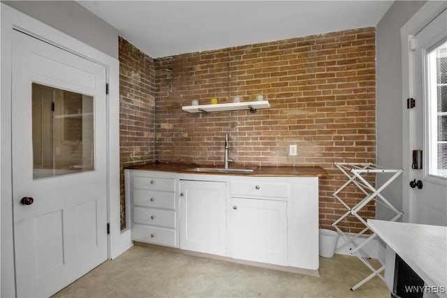2565 Bowen Rd, Elma, NY 14059 - kitchen featuring brick wall, white cabinetry, butcher block countertops, and open shelves