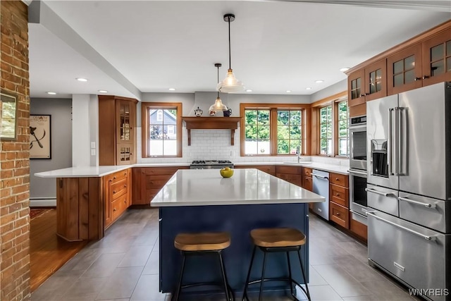 2565 Bowen Rd, Elma, NY 14059 - kitchen with appliances with stainless steel finishes, brown cabinets, light countertops, a center island, and recessed lighting