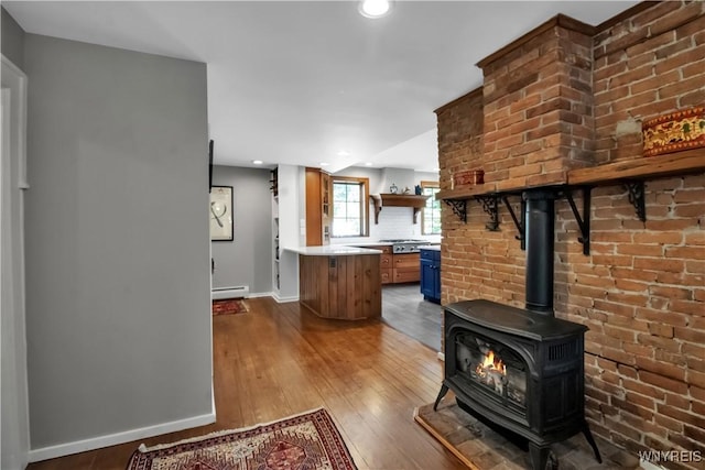 2565 Bowen Rd, Elma, NY 14059 - unfurnished living room featuring a baseboard heating unit, wood-type flooring, a wood stove, and recessed lighting