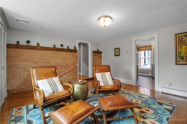 2565 Bowen Rd, Elma, NY 14059 - living area with a baseboard radiator, baseboard heating, wood finished floors, and brick wall