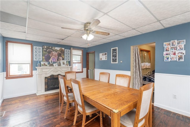 11 Fulton St, North Dansville, NY 14437 - dining area with a paneled ceiling, a wainscoted wall, ceiling fan, a fireplace, and wood finished floors