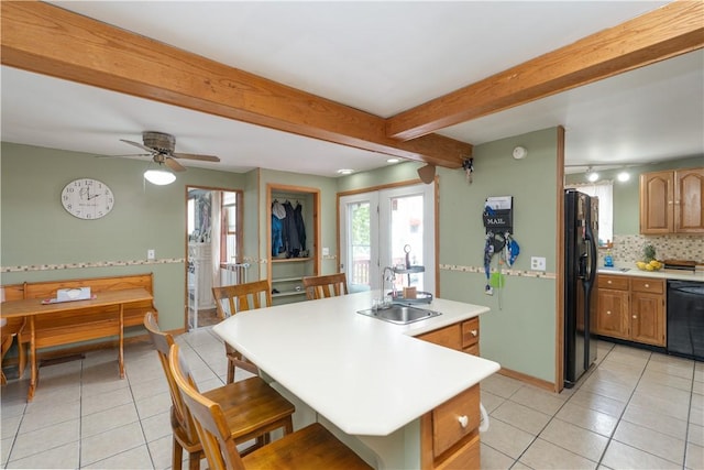 11 Fulton St, North Dansville, NY 14437 - kitchen featuring black appliances, light tile patterned floors, a center island, a kitchen breakfast bar, and light countertops