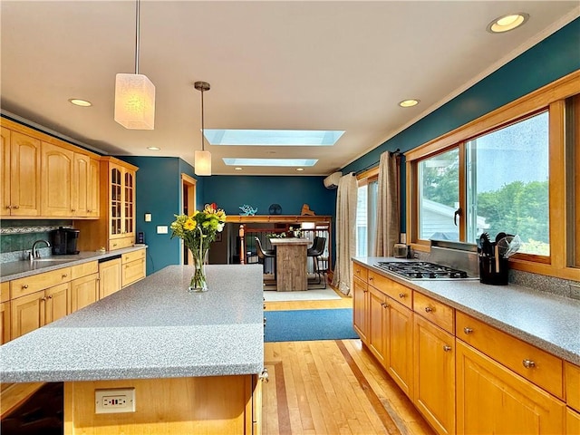 3 Suncrest Ter, Oneonta-City, NY 13820 - kitchen featuring a skylight, stainless steel gas stovetop, light wood-type flooring, a center island, and glass insert cabinets