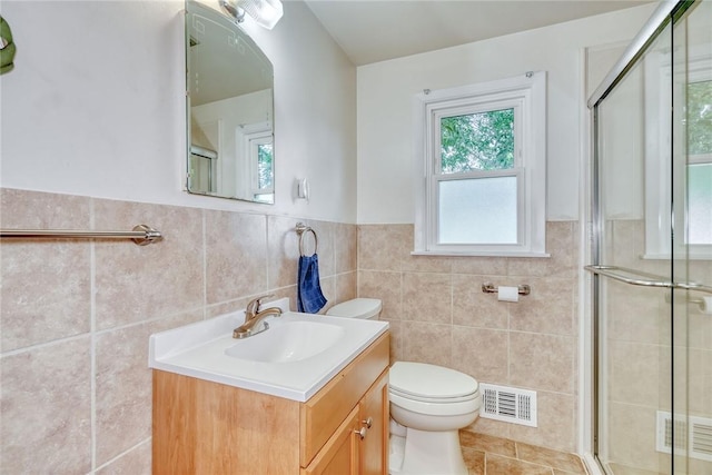 26 Catalina Dr, Irondequoit, NY 14622 - bathroom featuring tile walls, vanity, a stall shower, wainscoting, and tile patterned flooring