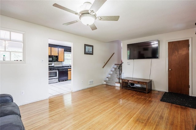 77 Chad Cir, Greece, NY 14616 - living room with light wood-style floors, stairway, and a ceiling fan