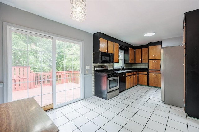 77 Chad Cir, Greece, NY 14616 - kitchen featuring black appliances, dark countertops, tasteful backsplash, light tile patterned flooring, and healthy amount of natural light