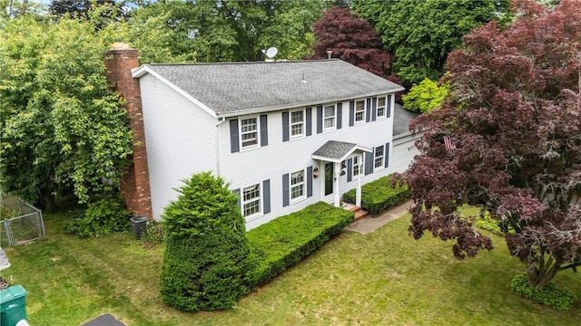 133 Parklands Dr, Greece, NY 14616 - view of front facade with a chimney, a shingled roof, a front yard, and view of wooded area