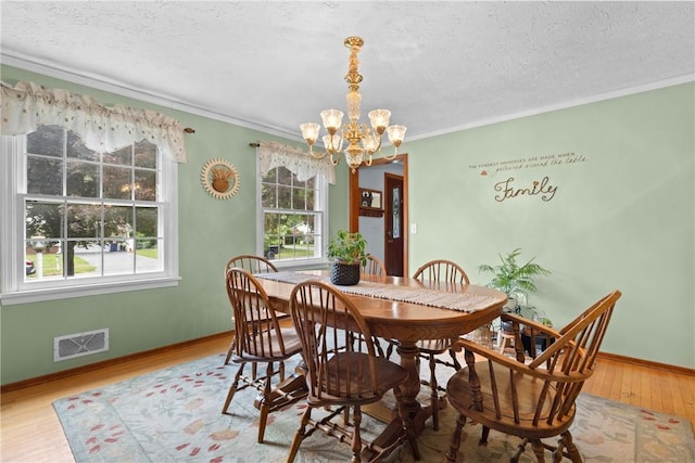 133 Parklands Dr, Greece, NY 14616 - dining room featuring a chandelier, healthy amount of natural light, wood finished floors, ornamental molding, and a textured ceiling