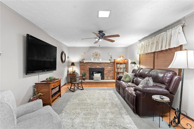 133 Parklands Dr, Greece, NY 14616 - living room featuring ceiling fan, a textured ceiling, a brick fireplace, and wood finished floors