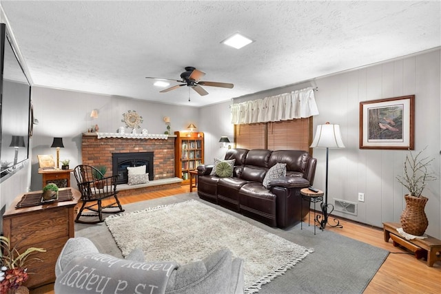 133 Parklands Dr, Greece, NY 14616 - living area featuring a ceiling fan, a textured ceiling, wood finished floors, and a brick fireplace